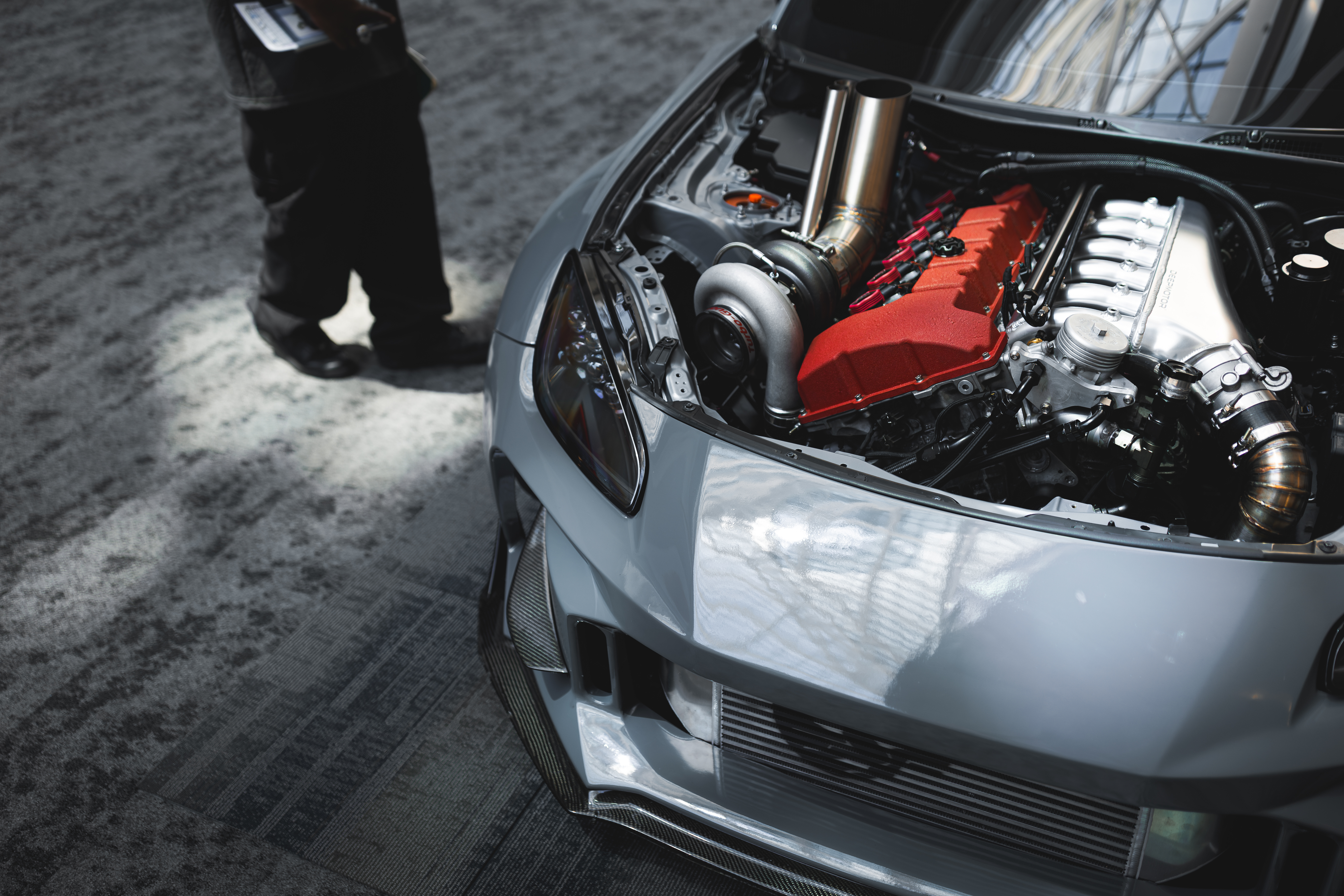 Close-up of a high-performance turbocharger with chrome and carbon fiber engine bay details